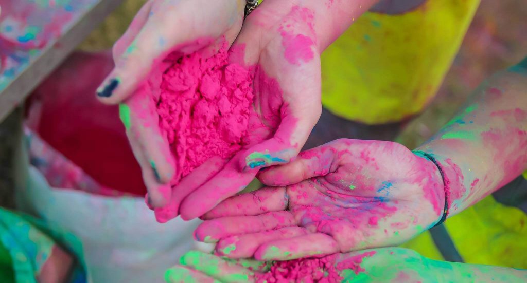 colour powder manufactured in the UK. Hands showing colour powder bright colours close up photo of holi colour powder made in the UK.